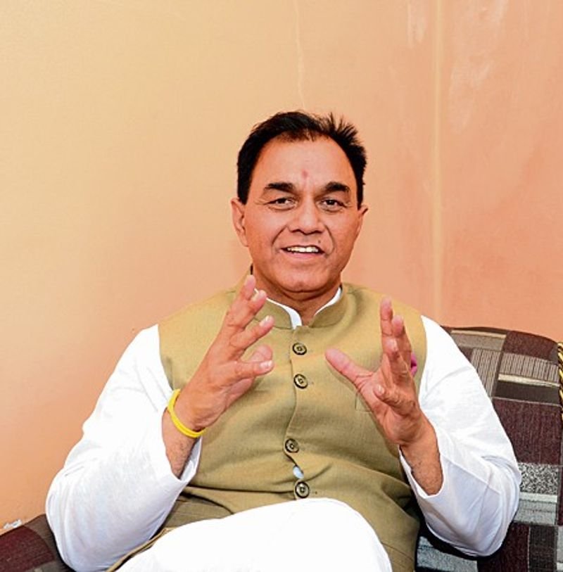 Dr. Raj Kumar Chabbewal seated in a green waistcoat and white kurta